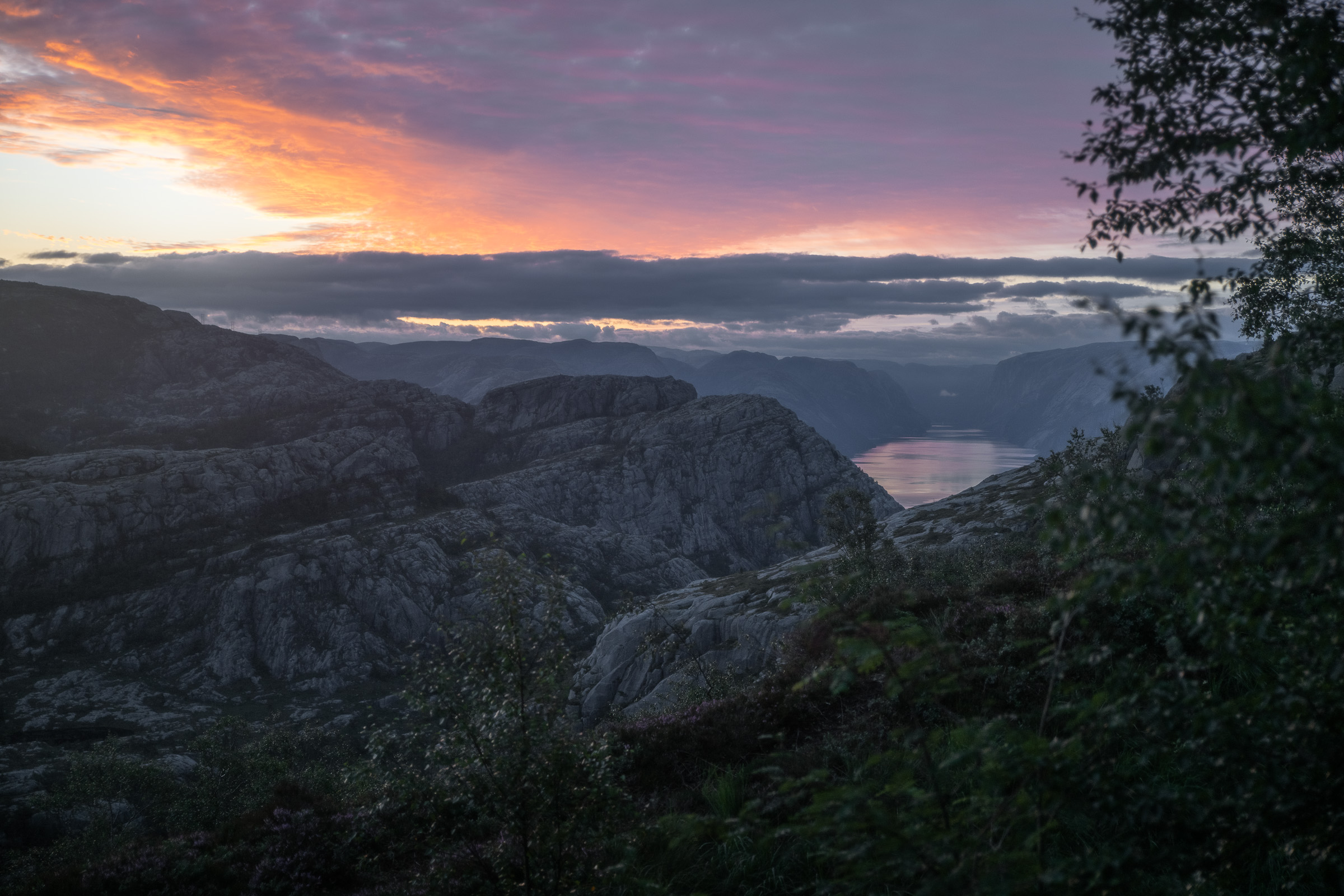Sunrise colors above mountains and low clouds near Preikestolen
