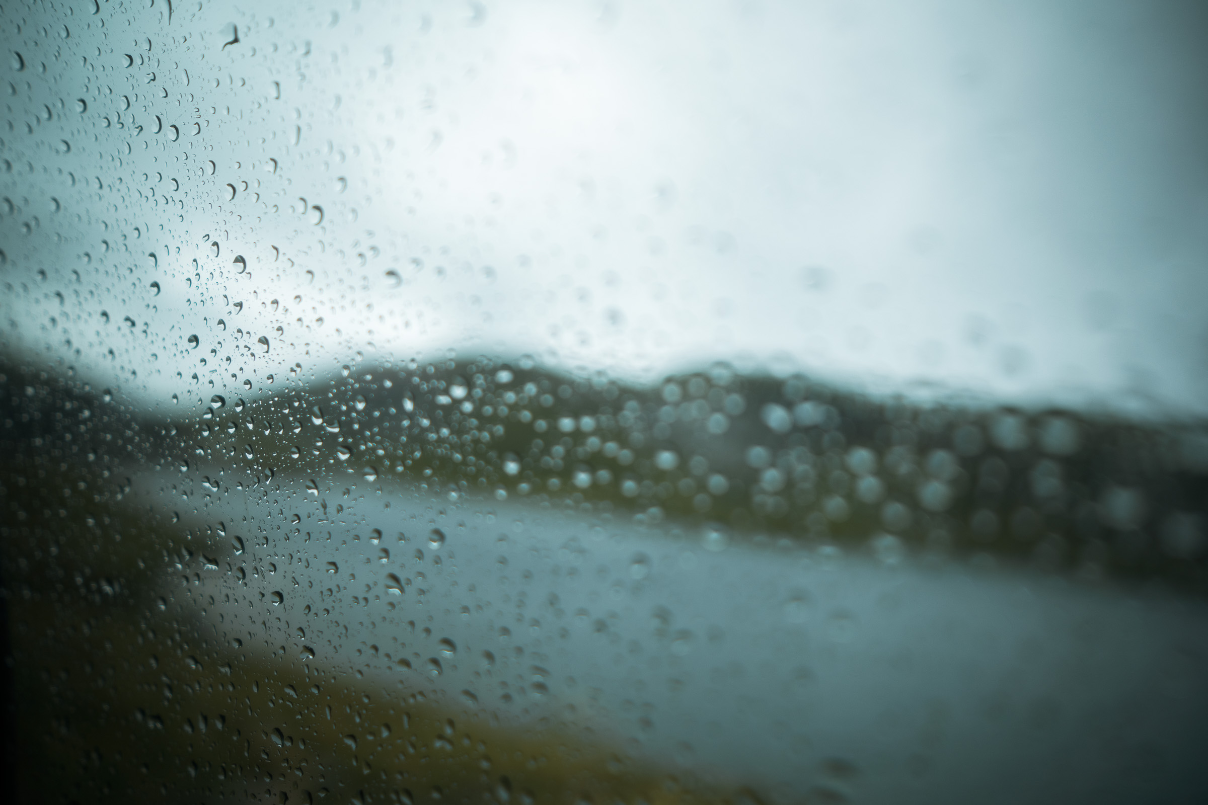 Raindrops on a window overlooking a grey Norwegian lake