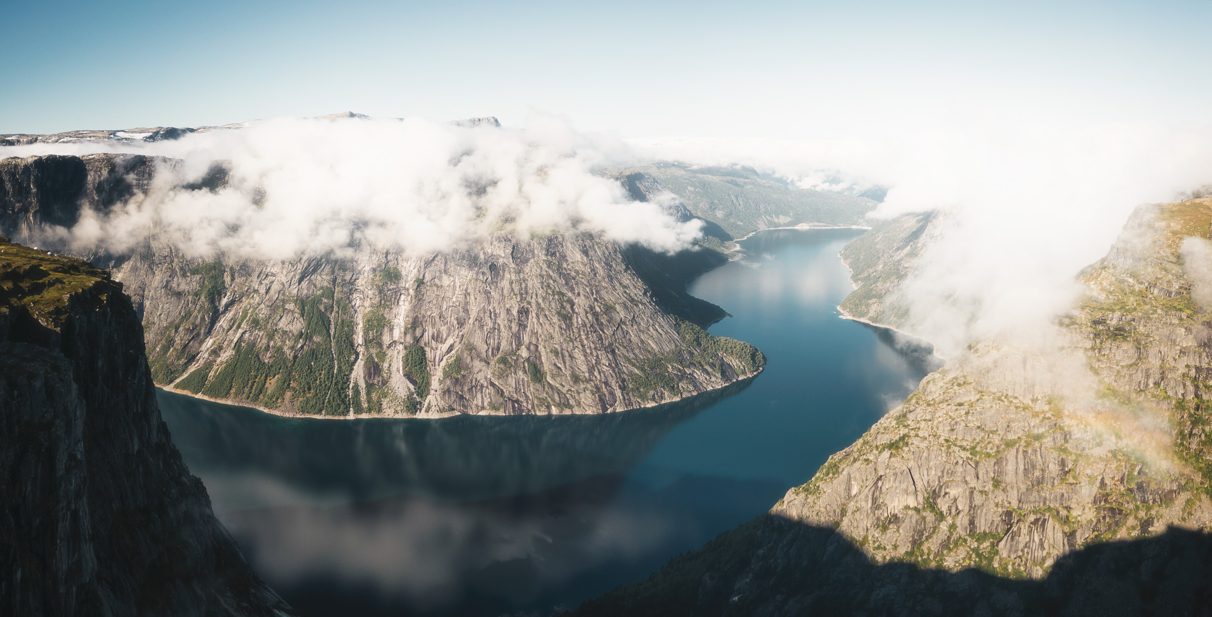 Morning light reaching a mountain lake through broken clouds