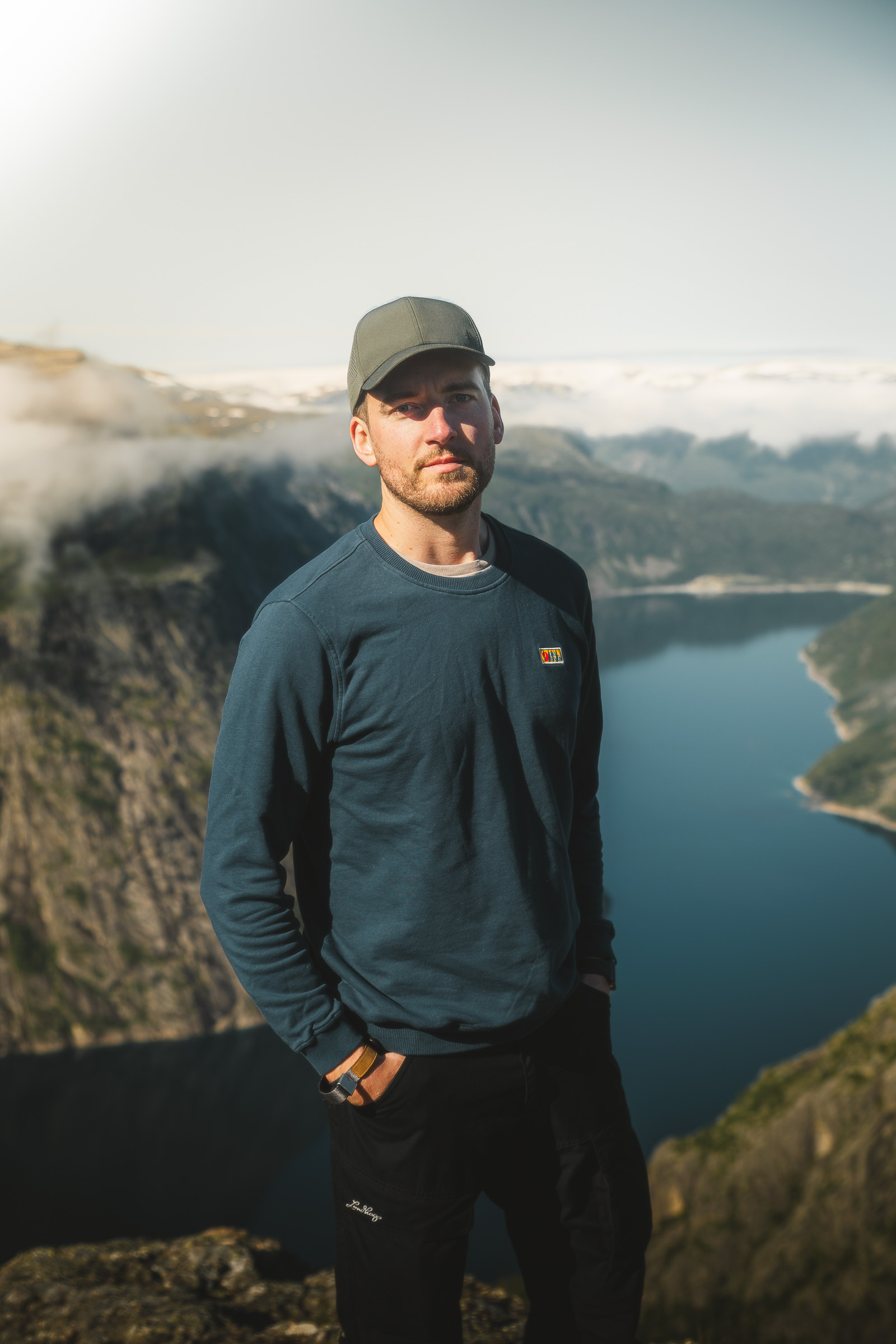 Male hiker in a cap standing above Ringedalsvatnet