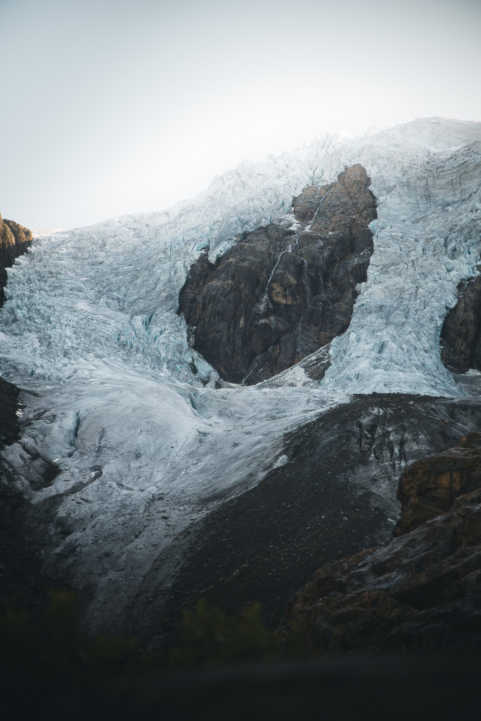 Blue ice of Buarbreen glacier surrounding dark rock towers