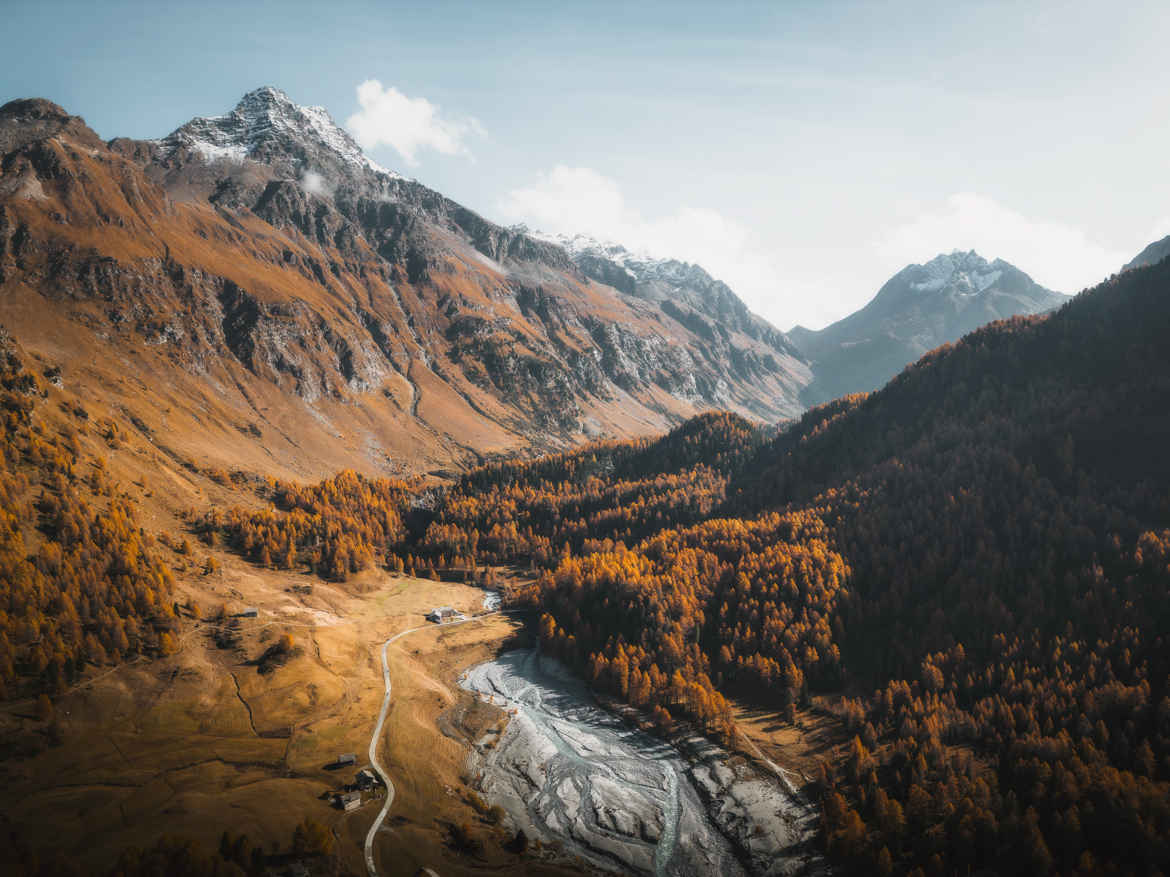 Aerial view of an alpine lake, braided river and autumn valley