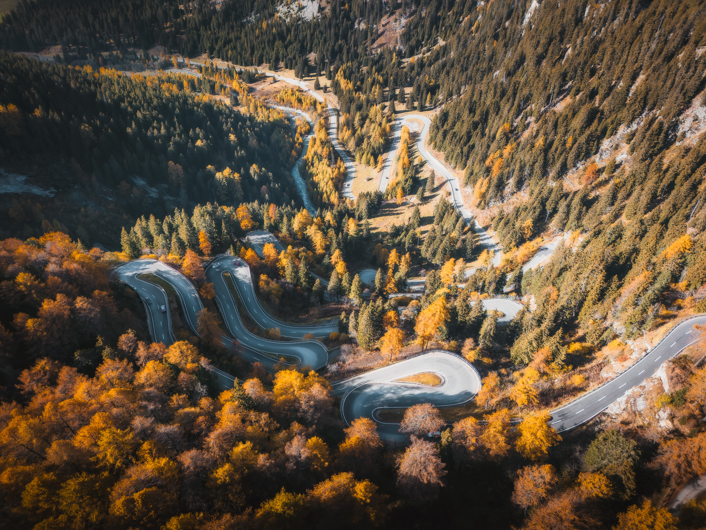 Aerial view of switchbacks crossing an autumn mountain valley