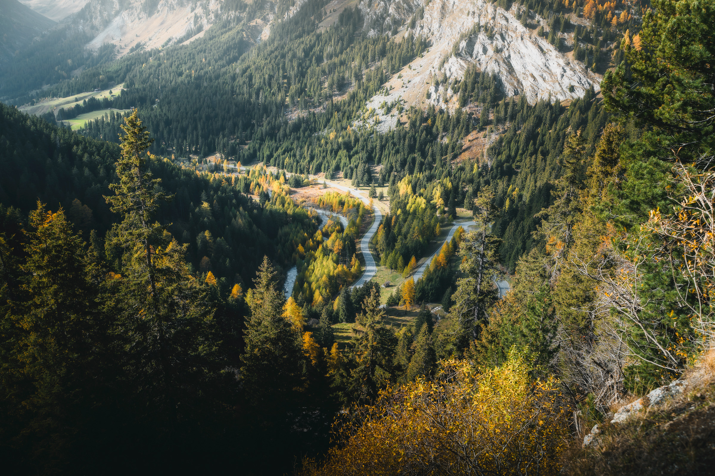 Winding road through an autumn valley in the Swiss Alps
