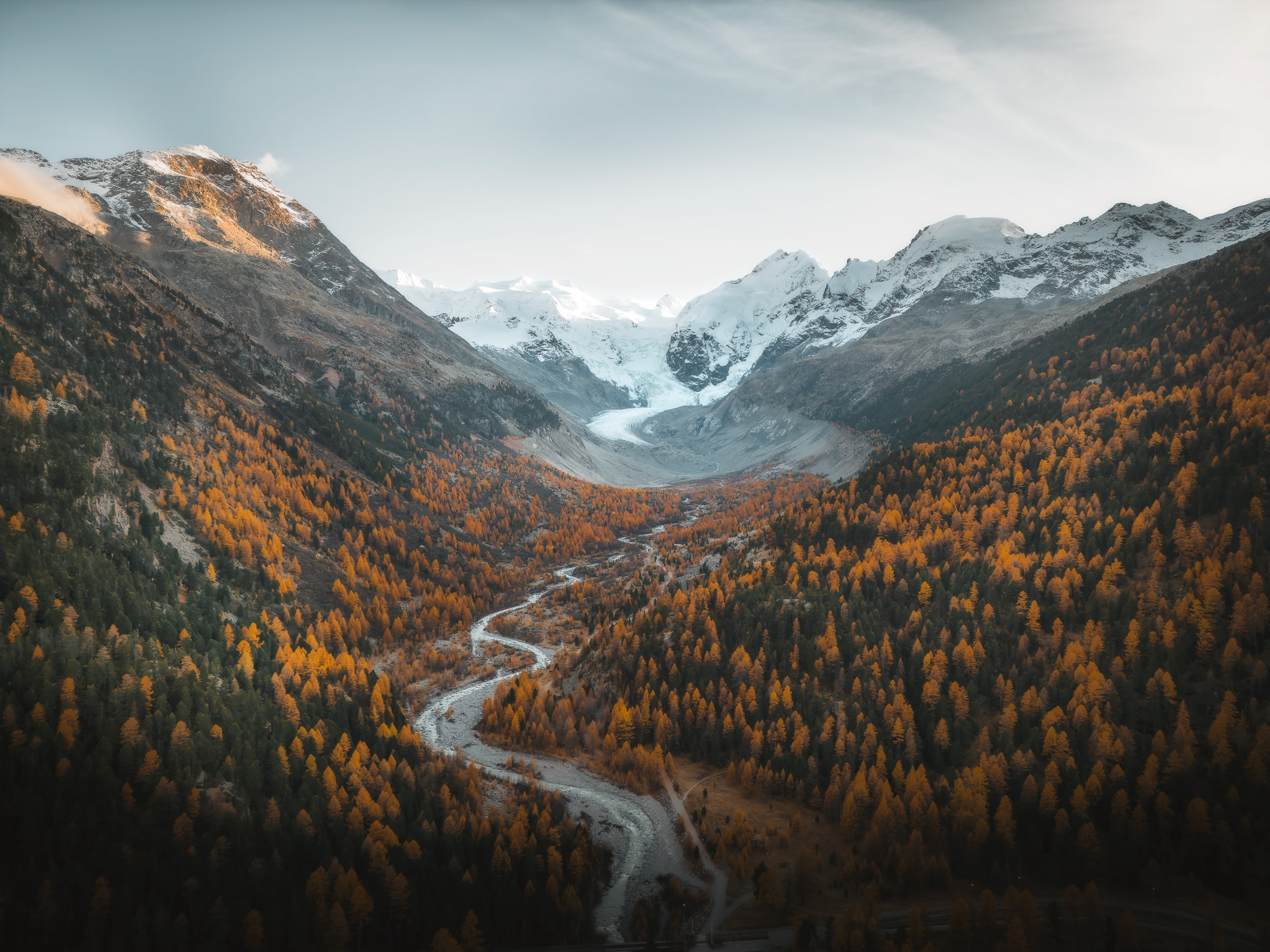 Aerial view of a glacier valley with a winding river and road