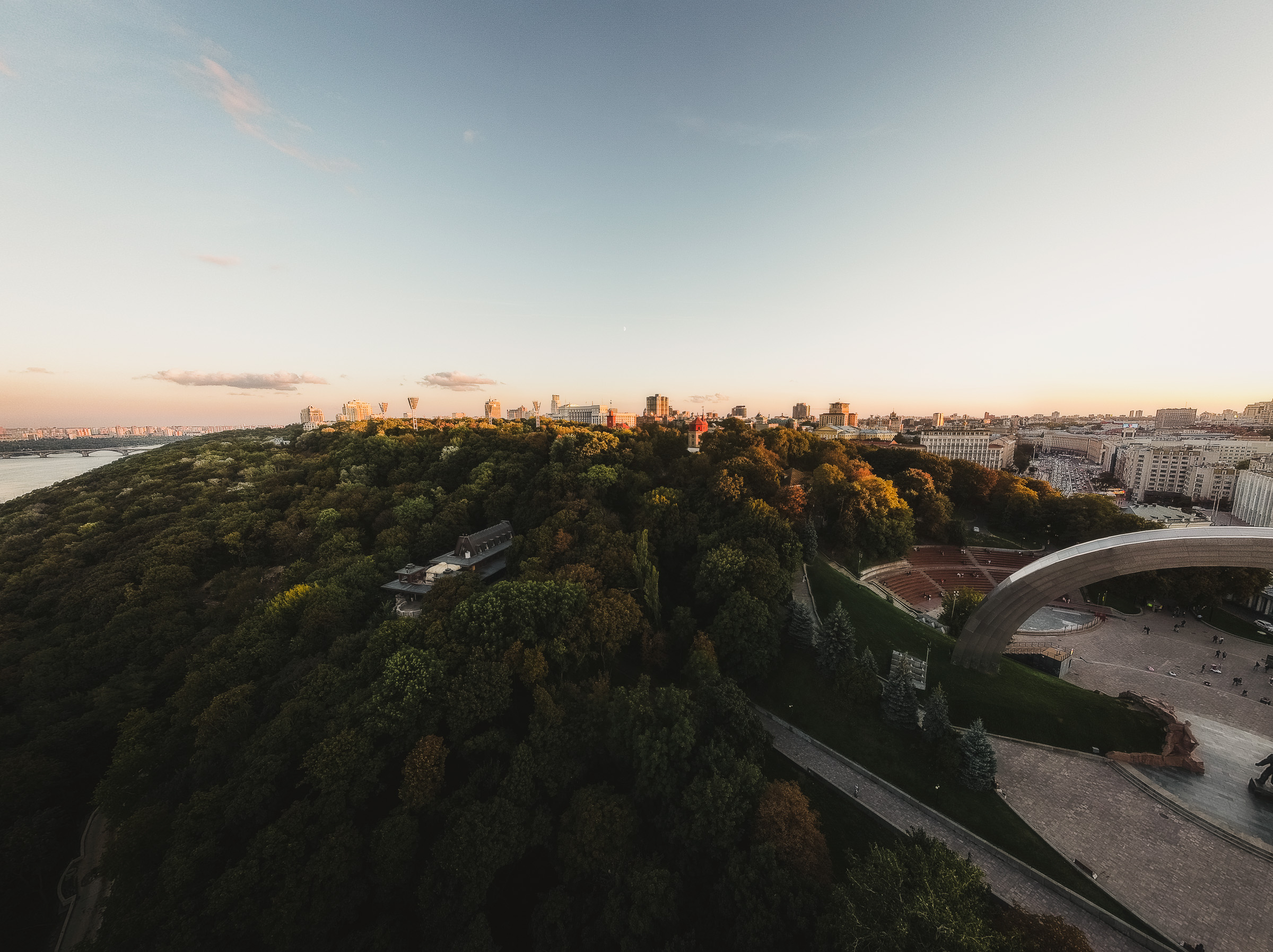 Aerial sunset view of a pedestrian bridge through a Kyiv park