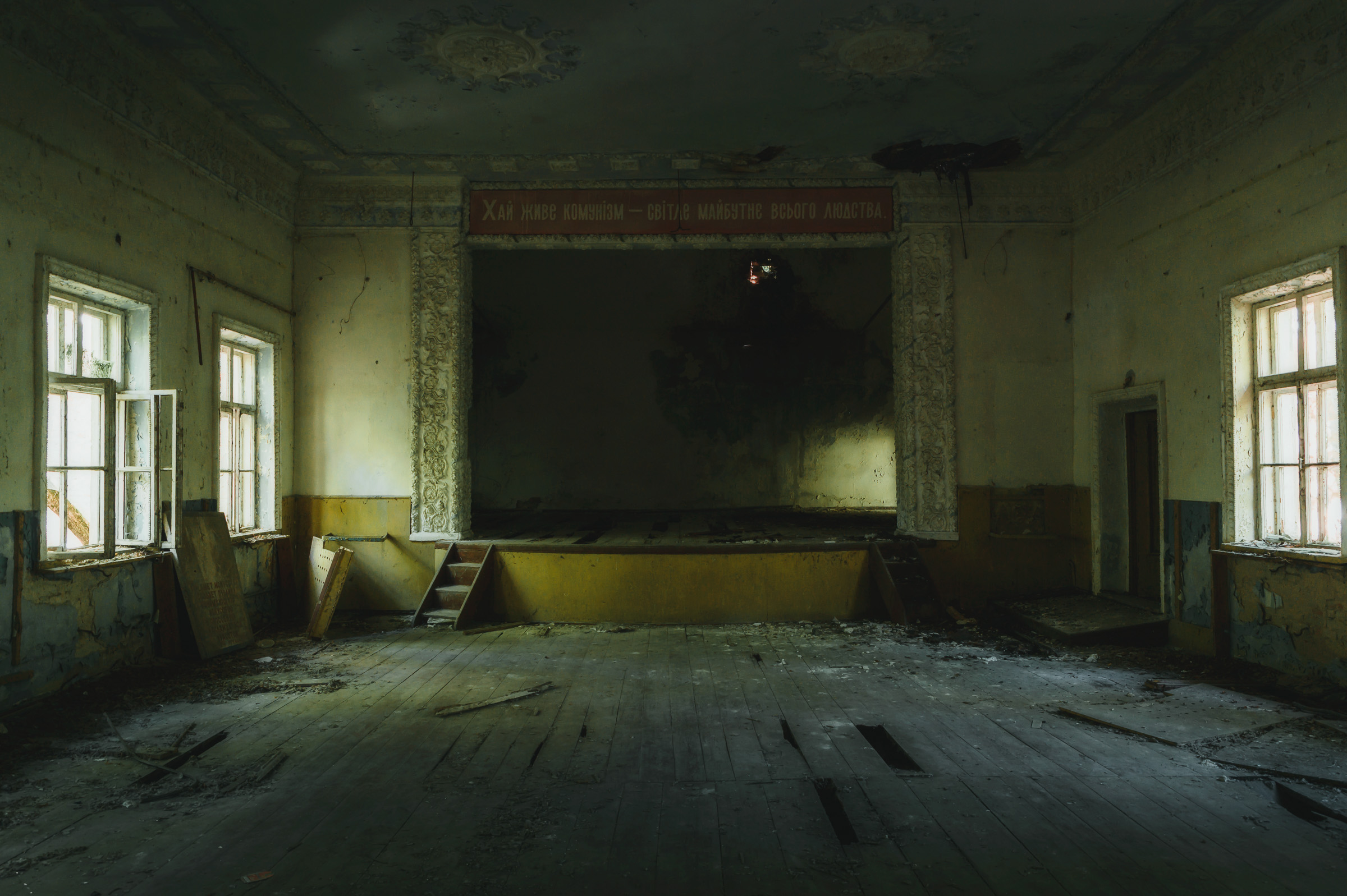 Empty auditorium with a faded Soviet banner in Pripyat