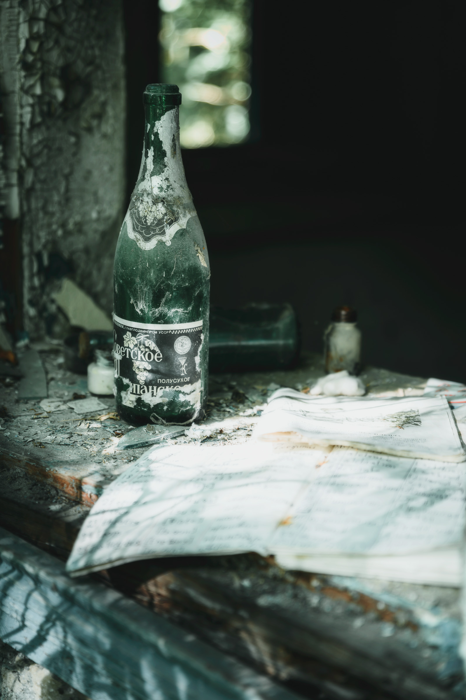 Glass bottle standing on a dusty tiled table