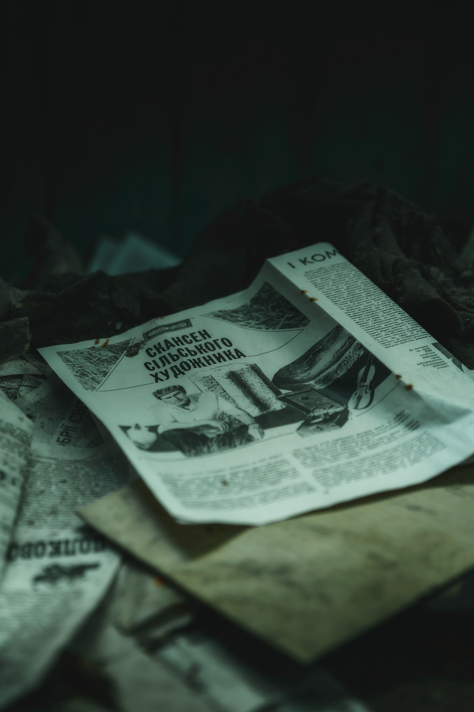 Old newspapers left in a dim abandoned room