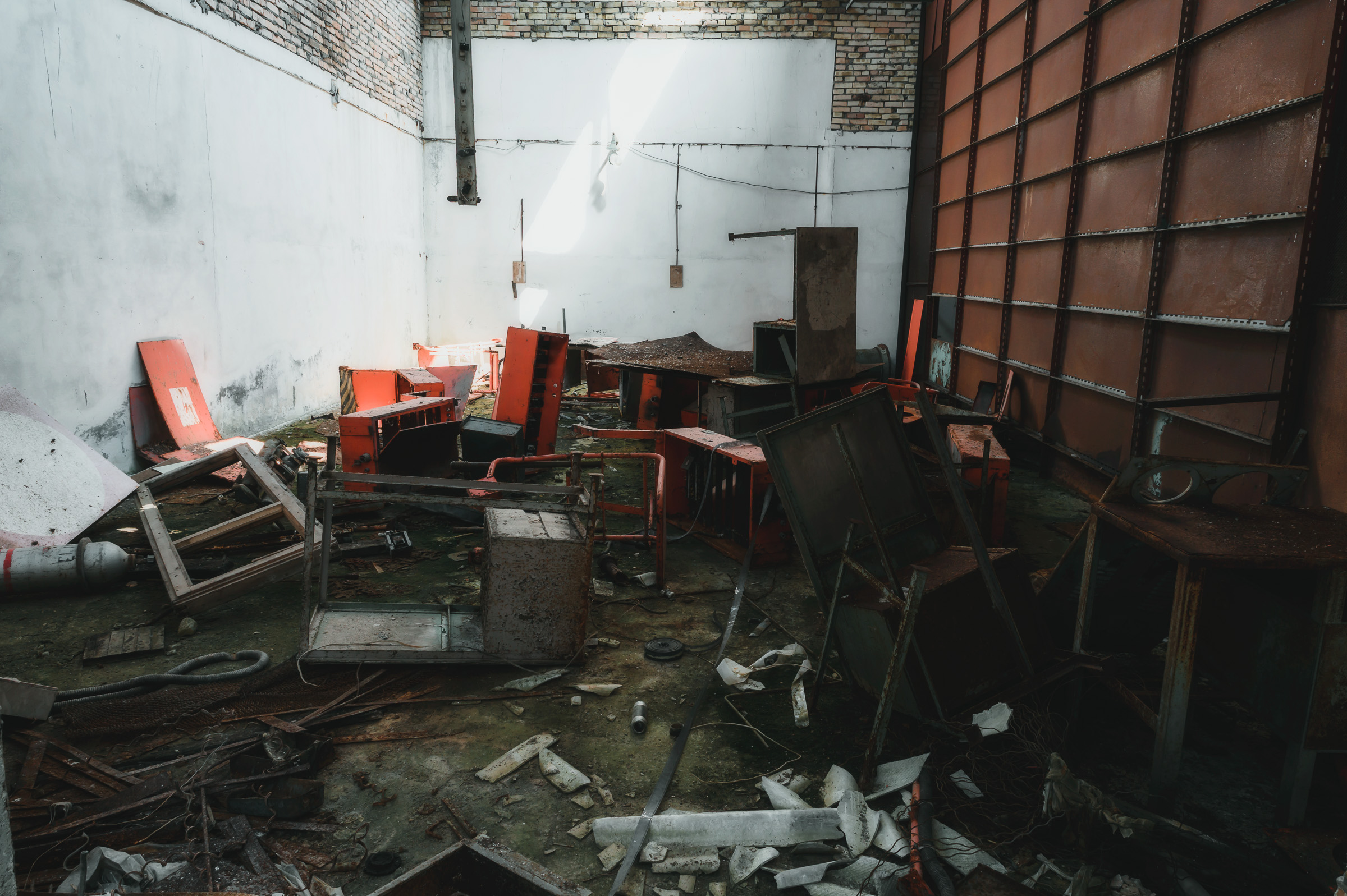 Overturned furniture and red chairs in a ruined classroom