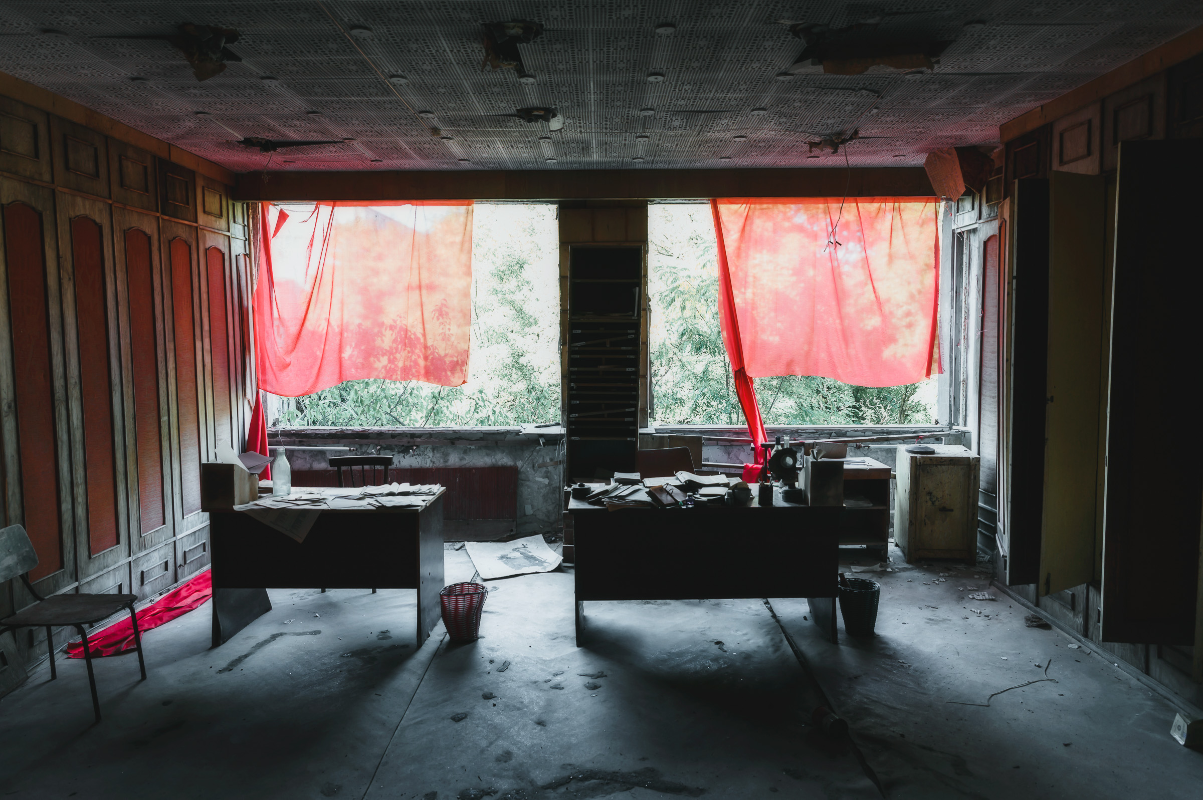 Red curtains glowing inside an abandoned room
