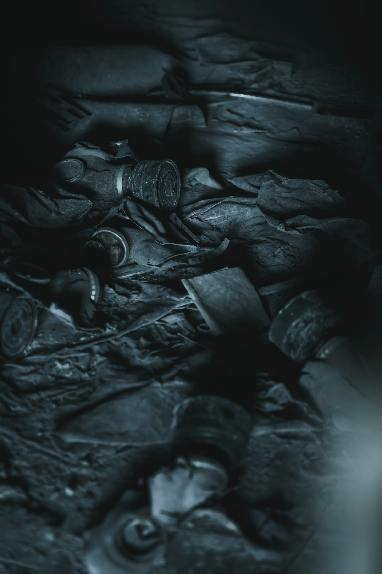 Pile of discarded gas masks in a dark room
