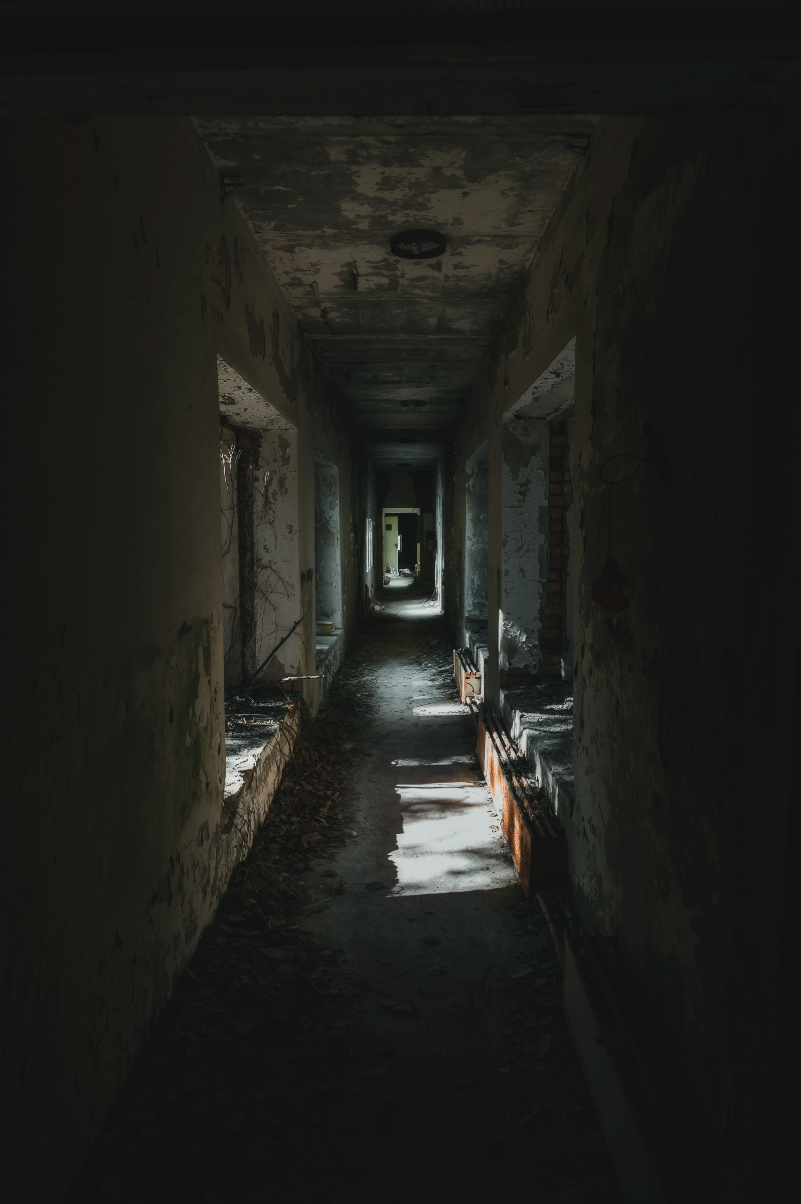 Long dark corridor inside an abandoned apartment block