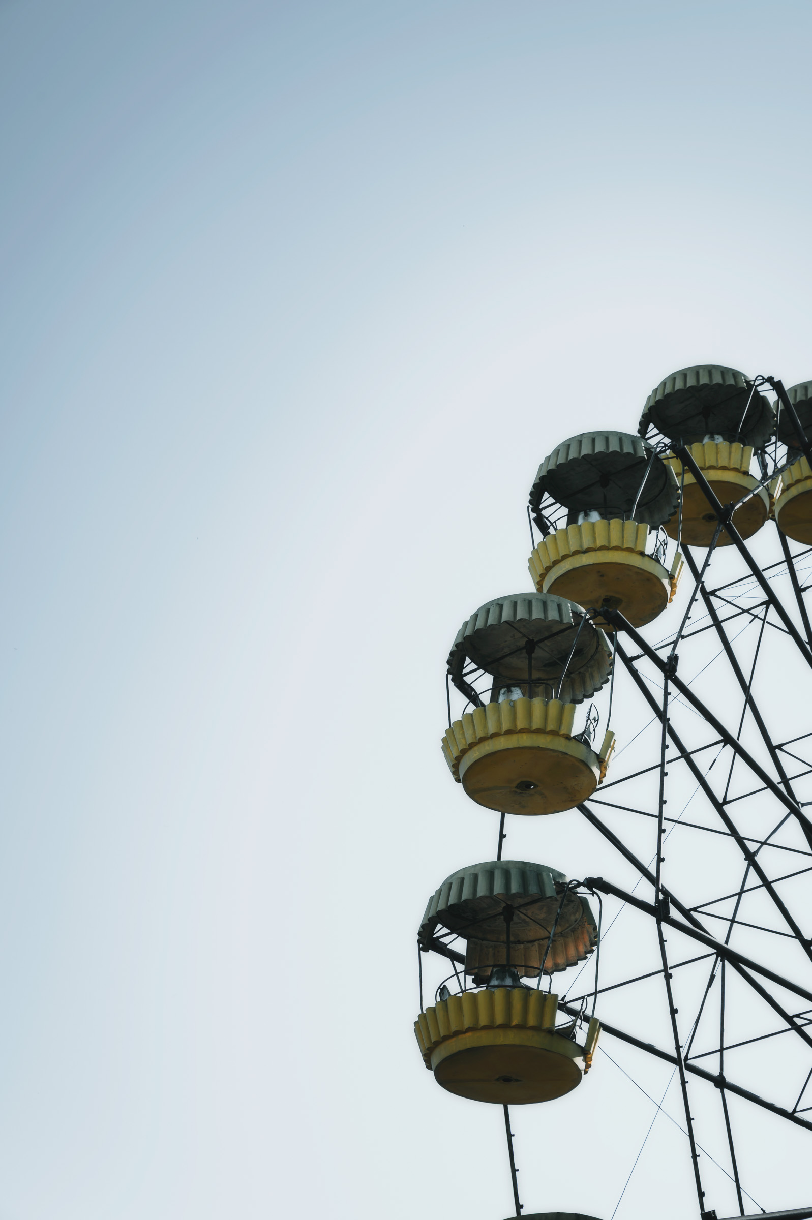 Yellow cabins of the Pripyat Ferris wheel against a clear sky