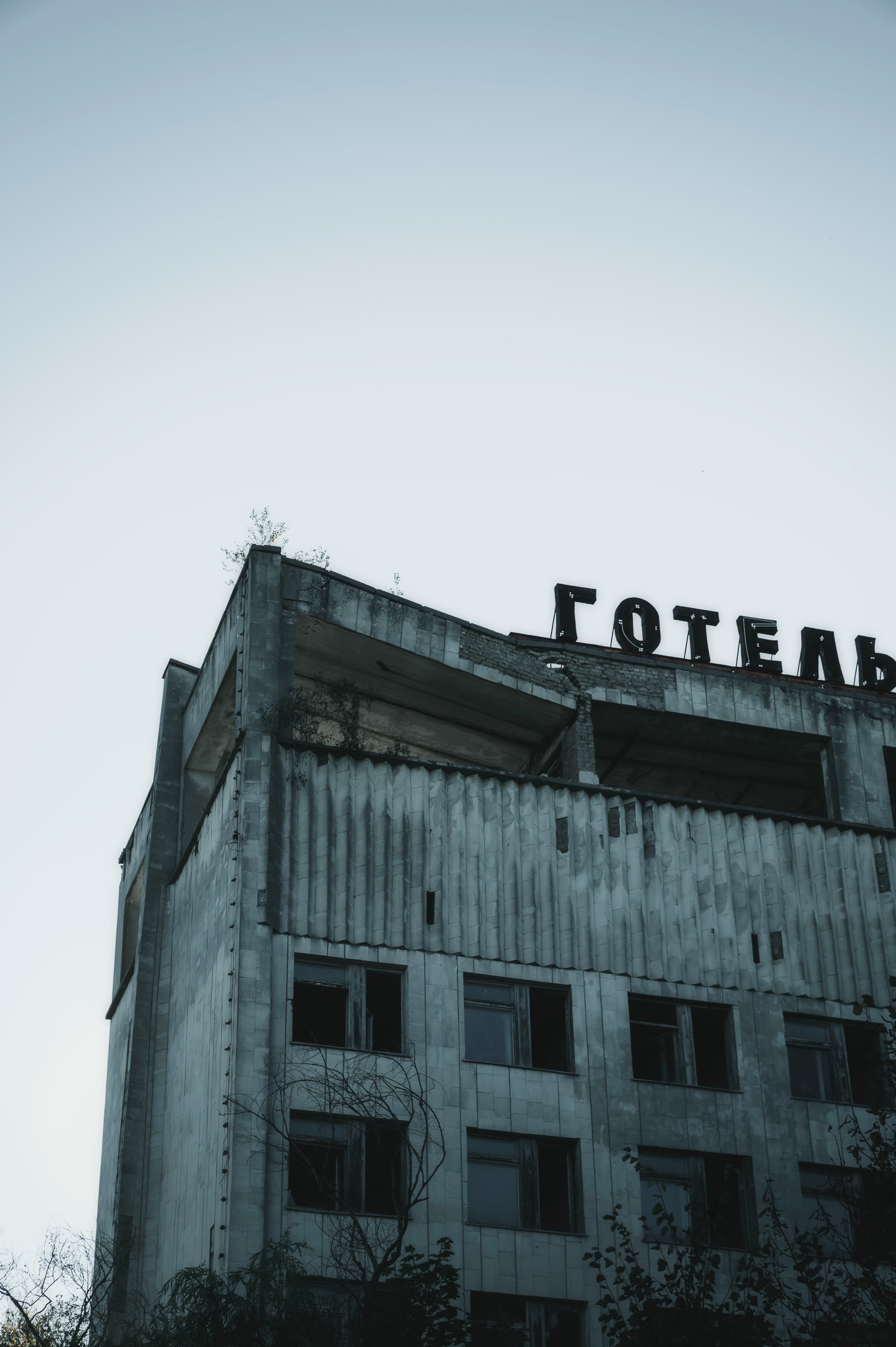 Abandoned Hotel Polissya facade beneath a pale sky