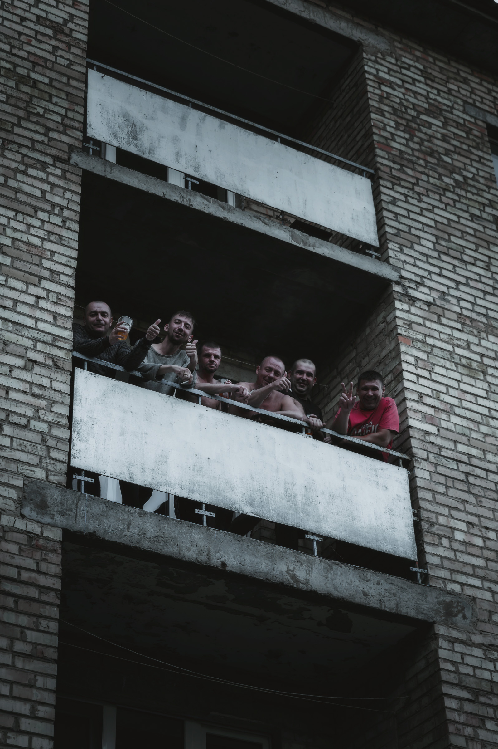 Visitors standing on the balcony of an abandoned apartment block