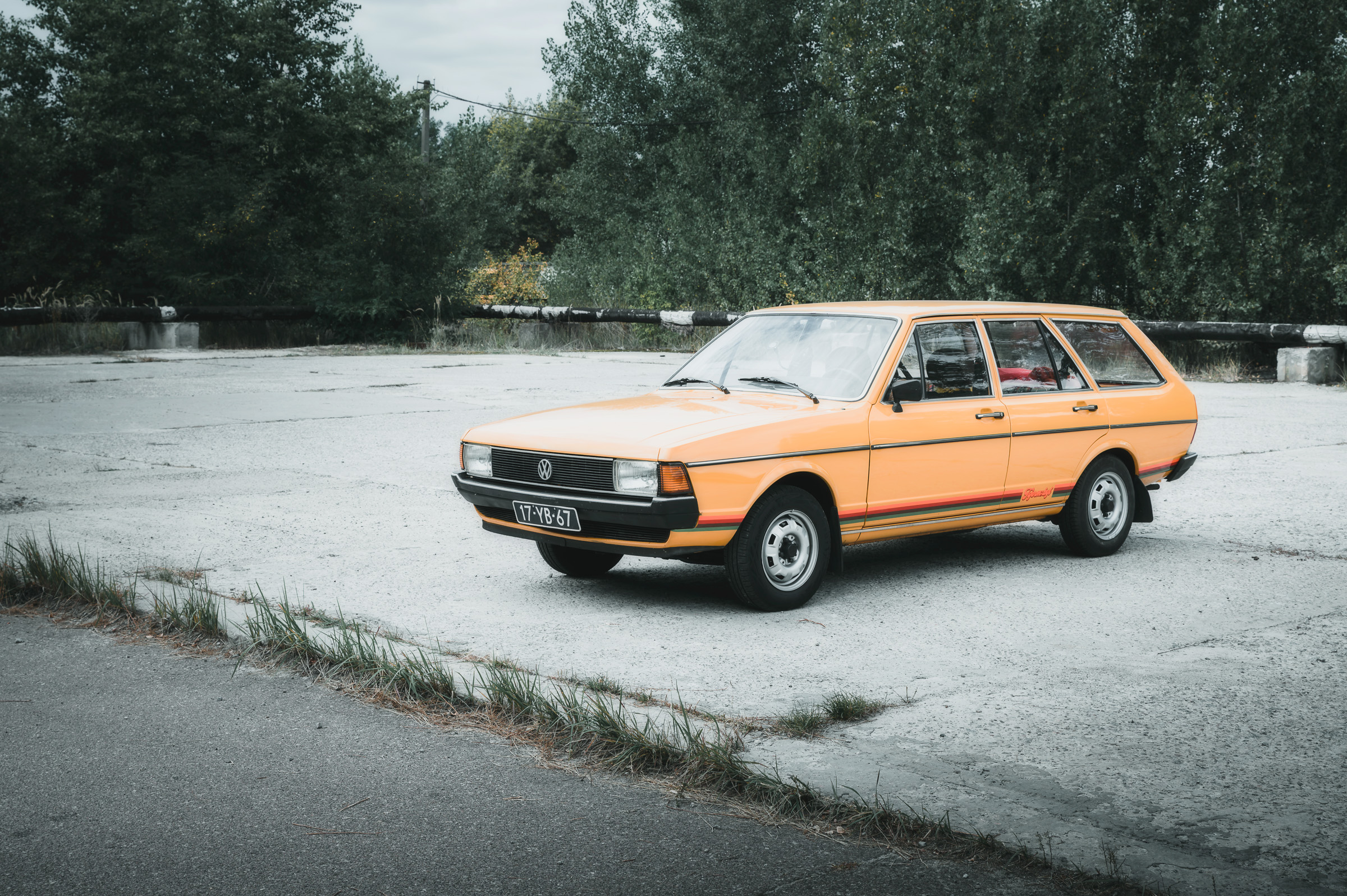 Orange vintage car parked on an empty paved square