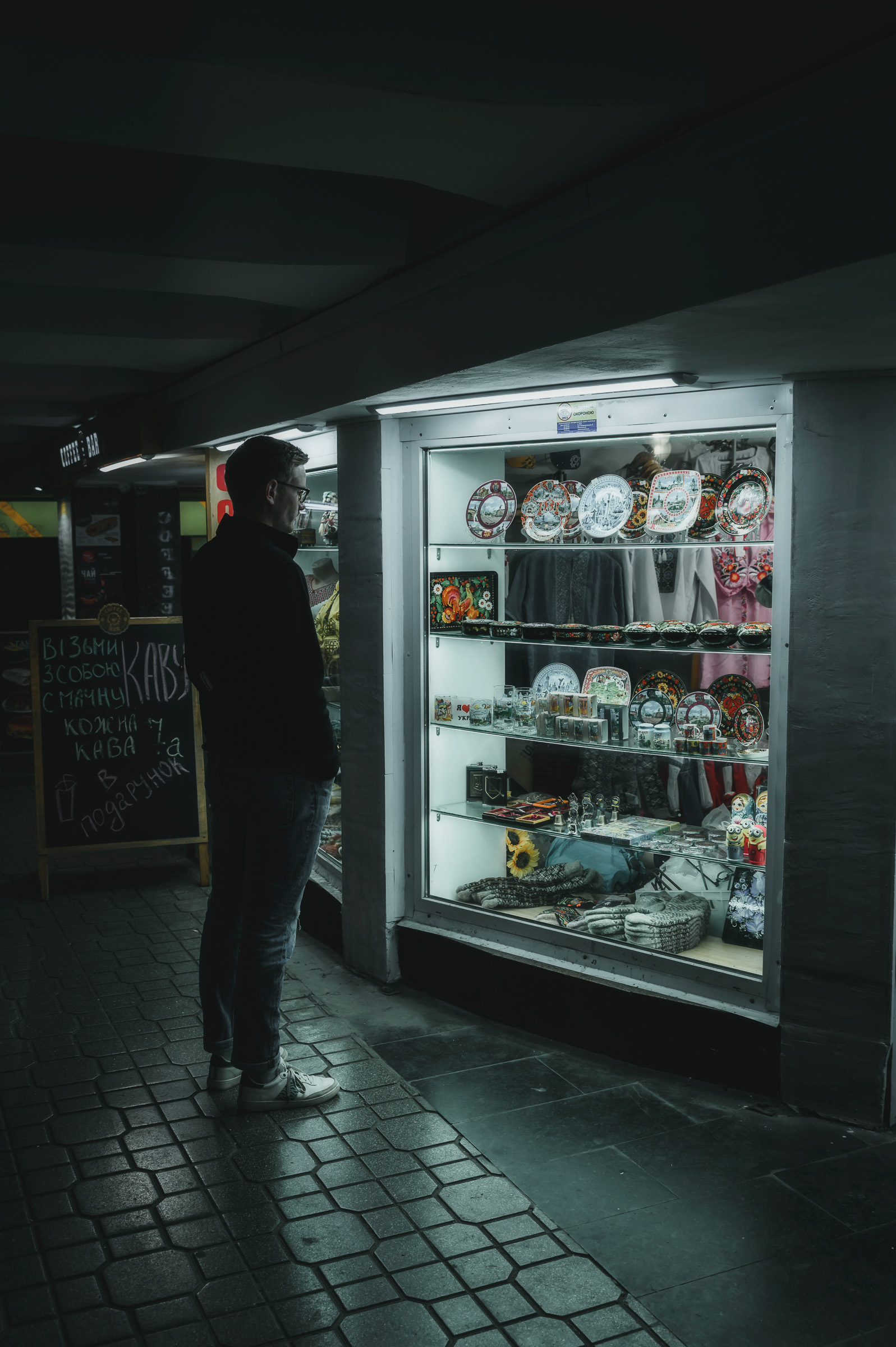 Person browsing an illuminated kiosk at night