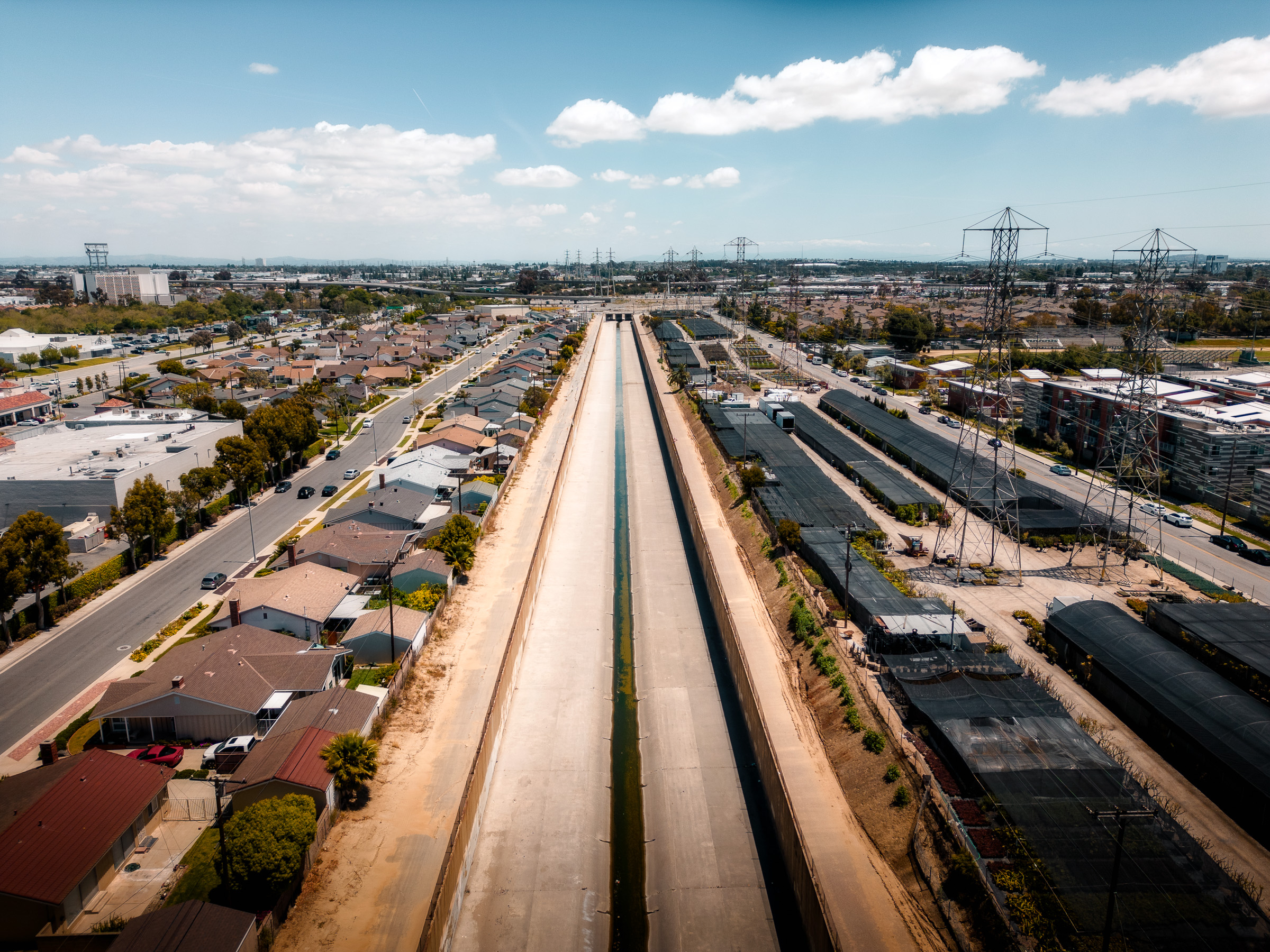 Aerial view along a concrete flood channel through Los Angeles