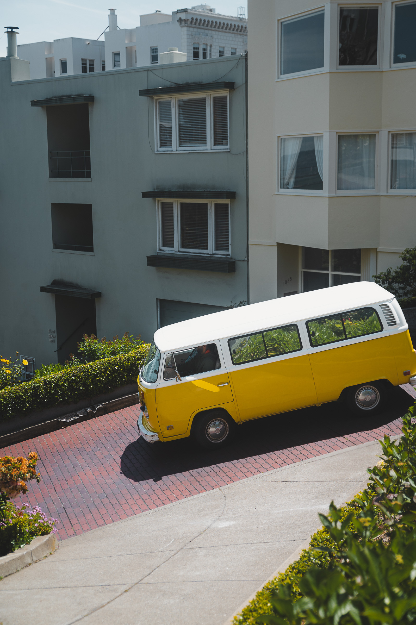 Yellow Volkswagen camper van on a steep residential street in San Francisco