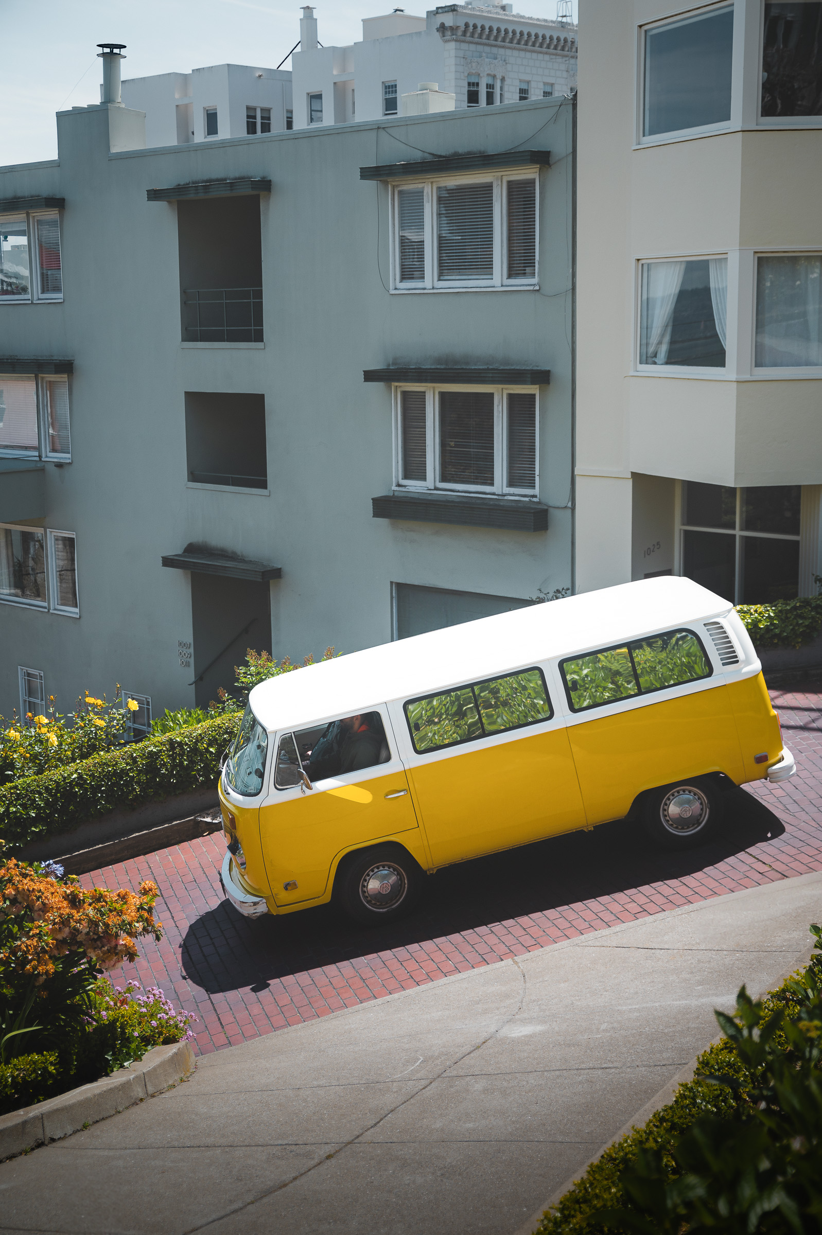 Yellow Volkswagen camper van parked on a steep San Francisco street