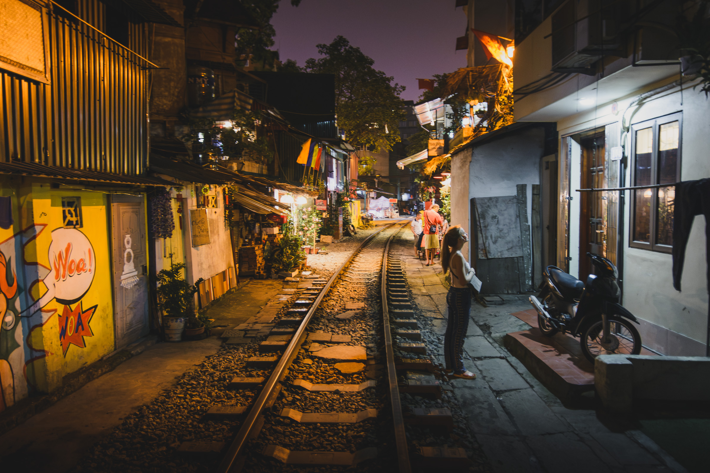 Illuminated railway tracks through Hanoi Train Street at night