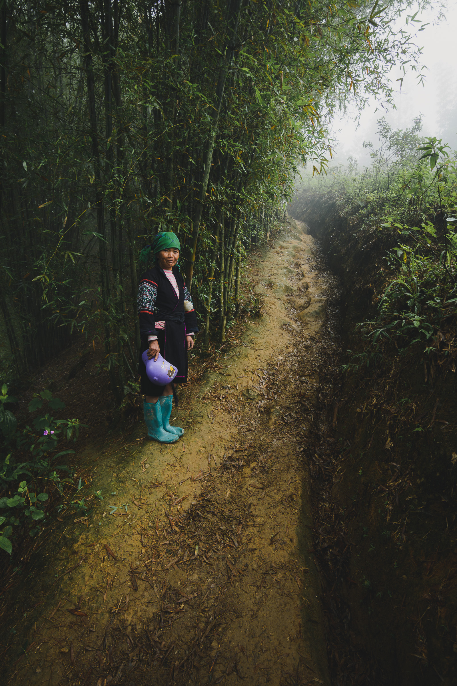 Person in traditional clothing on a narrow forest trail