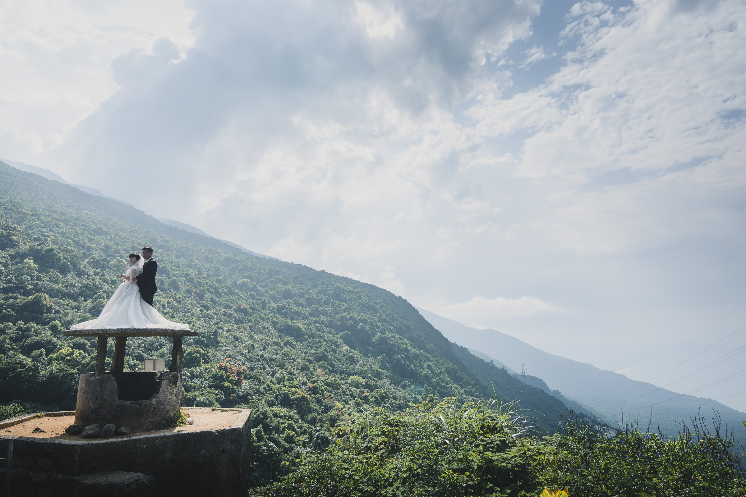 Bride and groom posing at a mountain viewpoint in Vietnam