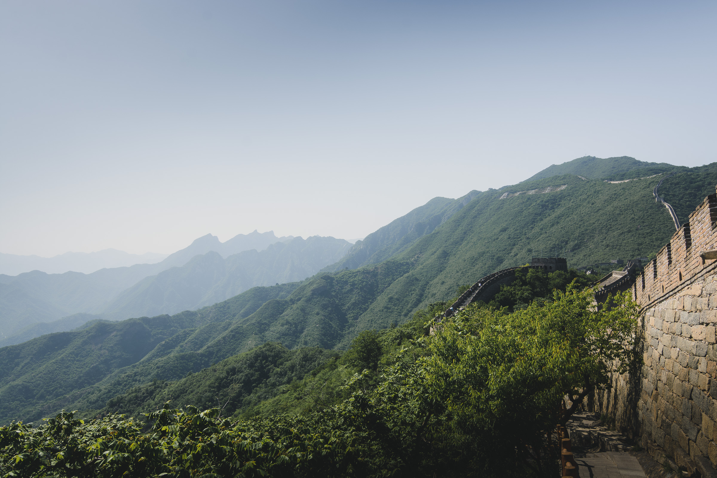 Great Wall of China winding across forested mountains