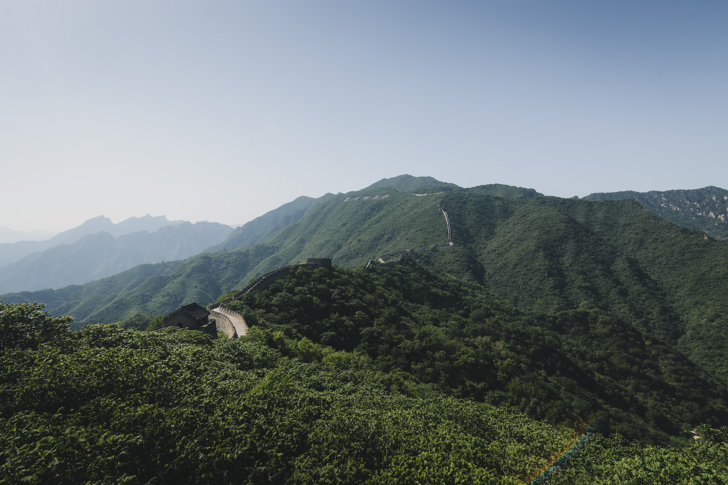 Great Wall of China crossing green mountain ridges