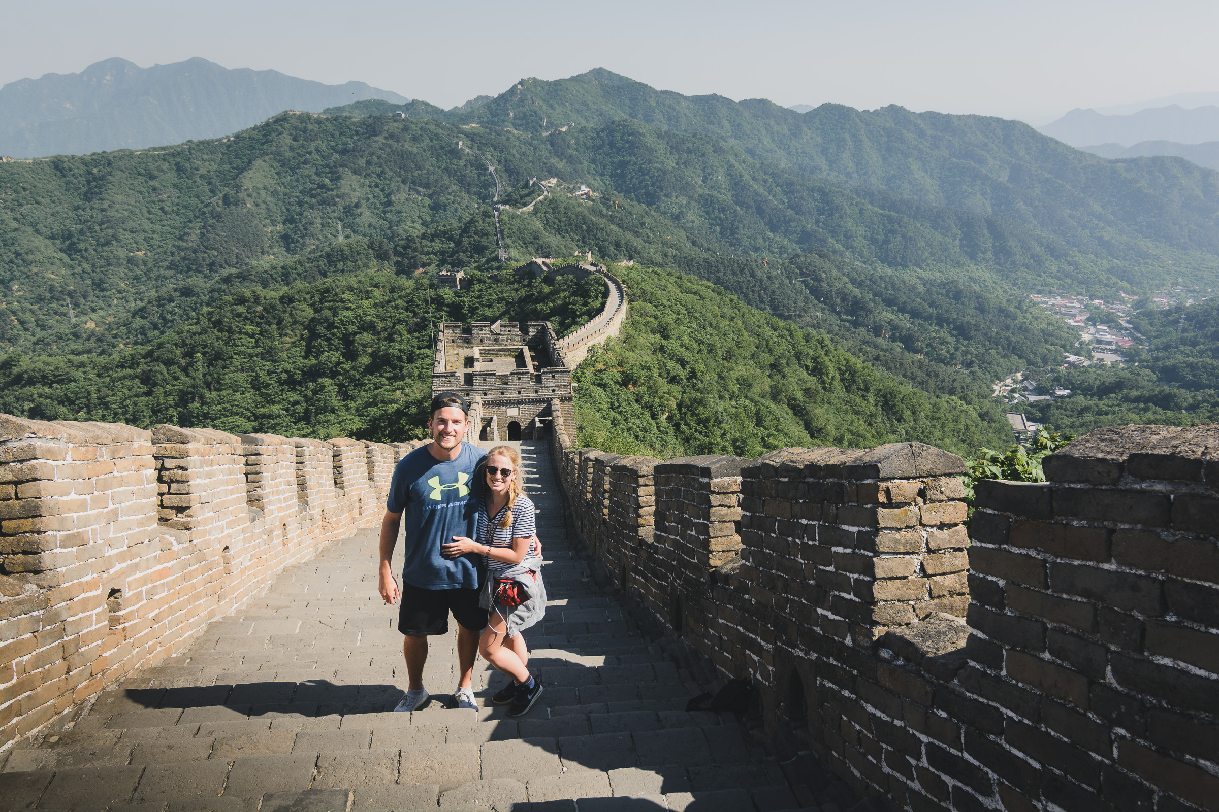 Two travelers standing on the steps of the Great Wall of China